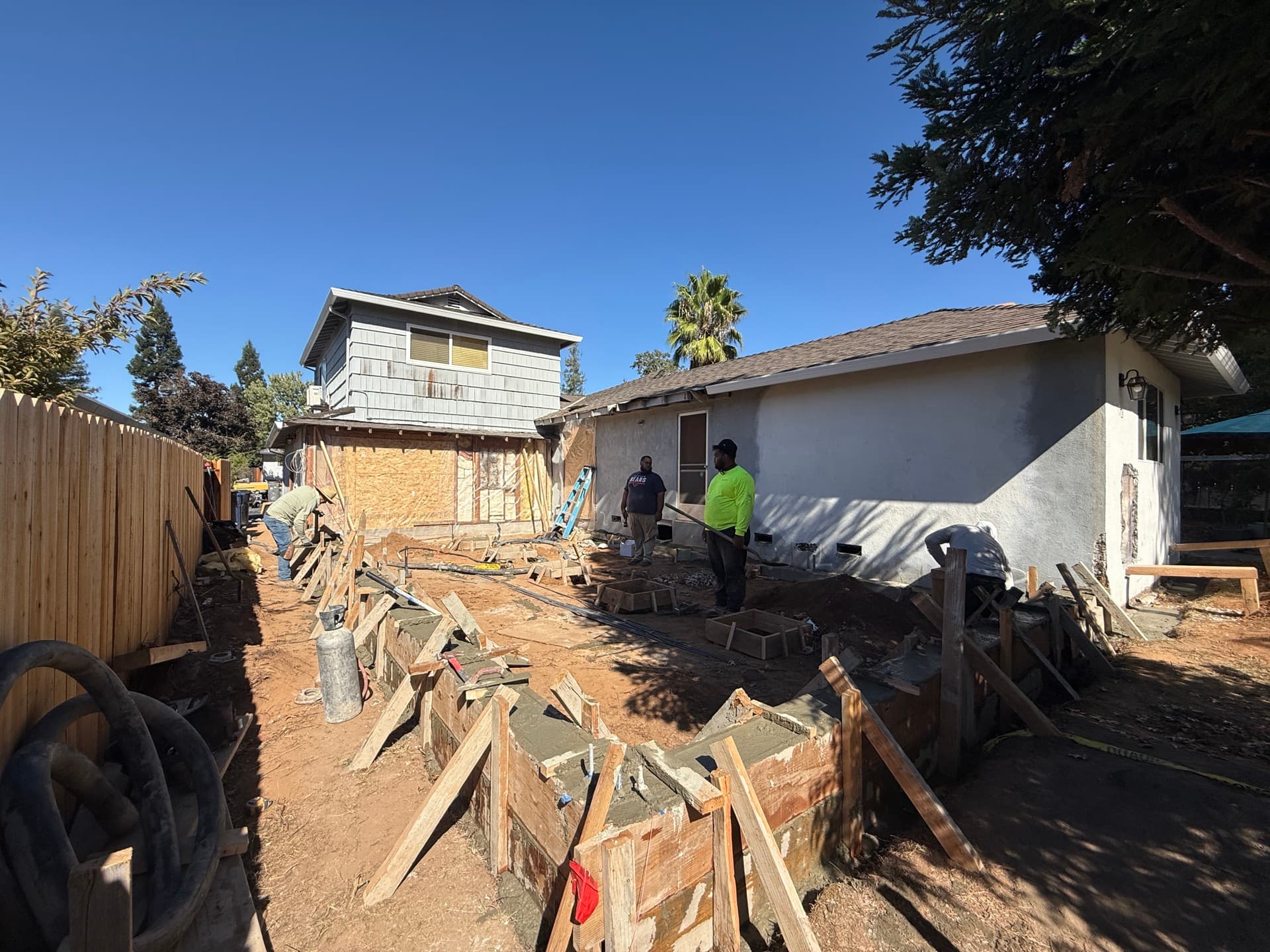 Wood-framed Fair Oaks attached ADU mid-construction with new studs, sheathing and roof trusses on a poured slab foundation