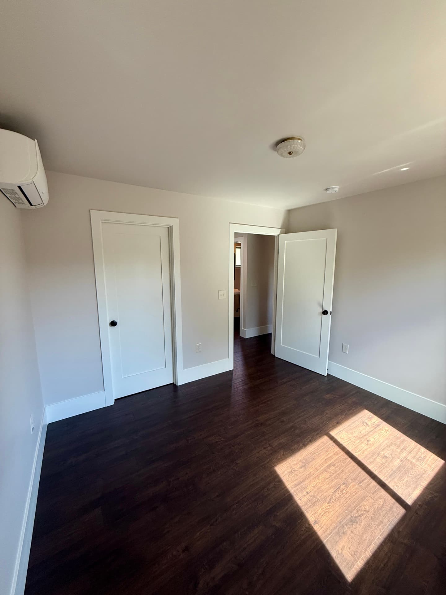 Roseville detached ADU — finished bedroom with dark hardwood — gallery thumbnail 6